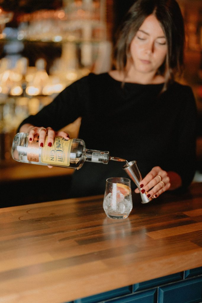 Woman making gin cocktail